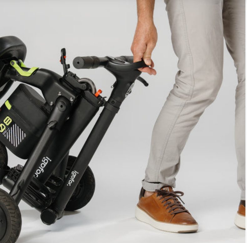 Igofor scooter folded and wheeled by hand, showing its portability
